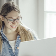 Woman smiling while looking at a laptop screen