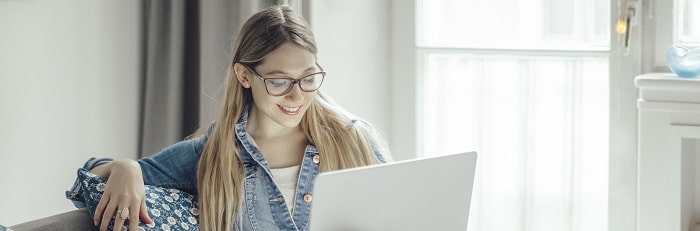 Woman smiling while looking at a laptop screen