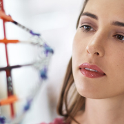 woman looking at a model of DNA