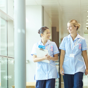 Group of four nurses walking along a hospital corridor