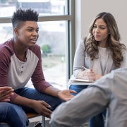 Young adult speaks to a group sitting in a circle