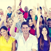 A group of people all with their hands raised.