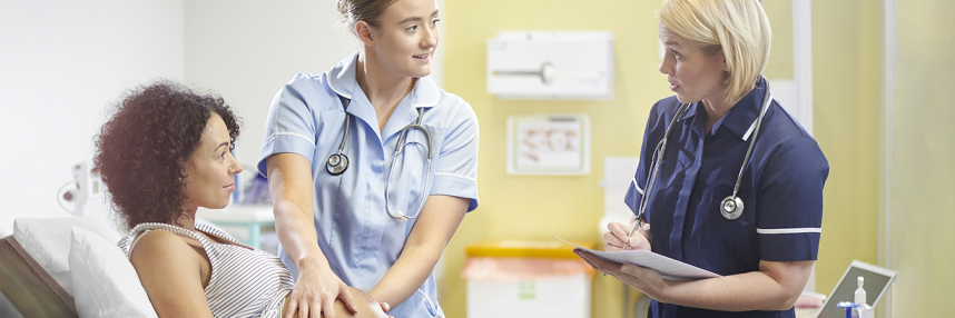 A pregnant woman is examined by a student midwife overseen by a senior team member
