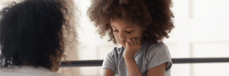 Young girl looking apprehensive while speaking to health visitor