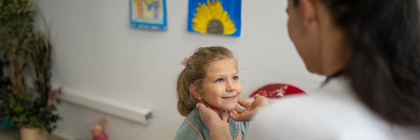 Female clinician examining little girl in clinic