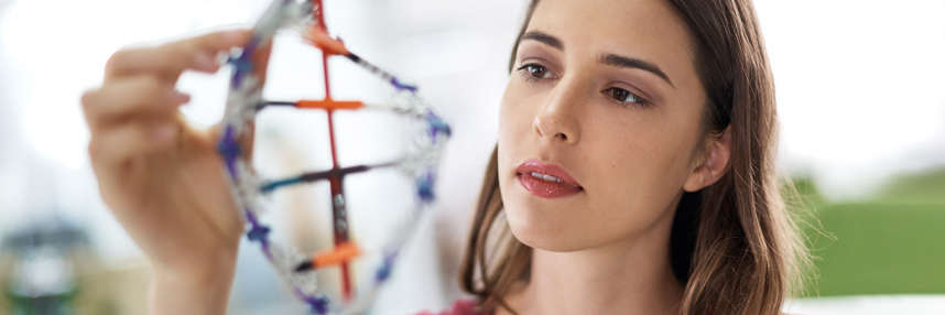 woman looking at a model of DNA
