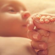 Mother holding the hand of her newborn baby