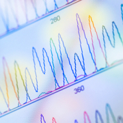A close-up view of a screen with multicoloured graph lines created from the sequencing of dna